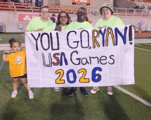 Photo of Trevor Mohrmann, Robin Friday, Swimmer Ryan Nash, Lindsay Mohrmann and below left Ryan's cousin with banner to cheer on Ryan at Special Olympics USA Games in late June in Minneapolis, MN. 